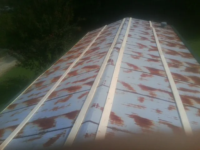 Rusted metal roof panels with new wood purlins before replacement — Storm Damage Roof Repair in Mc Donald by Roofing Brothers