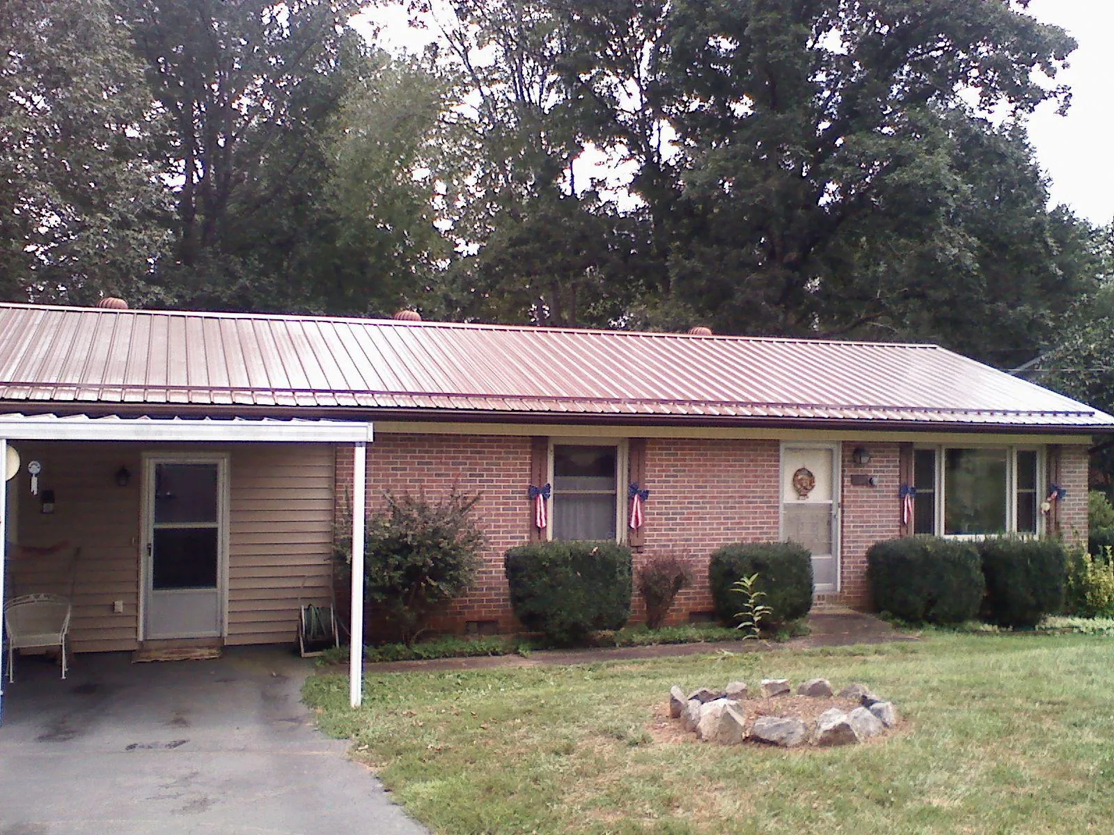 Bronze metal roof and carport on a brick ranch home — Roof Repair work by our crew in Mc Donald